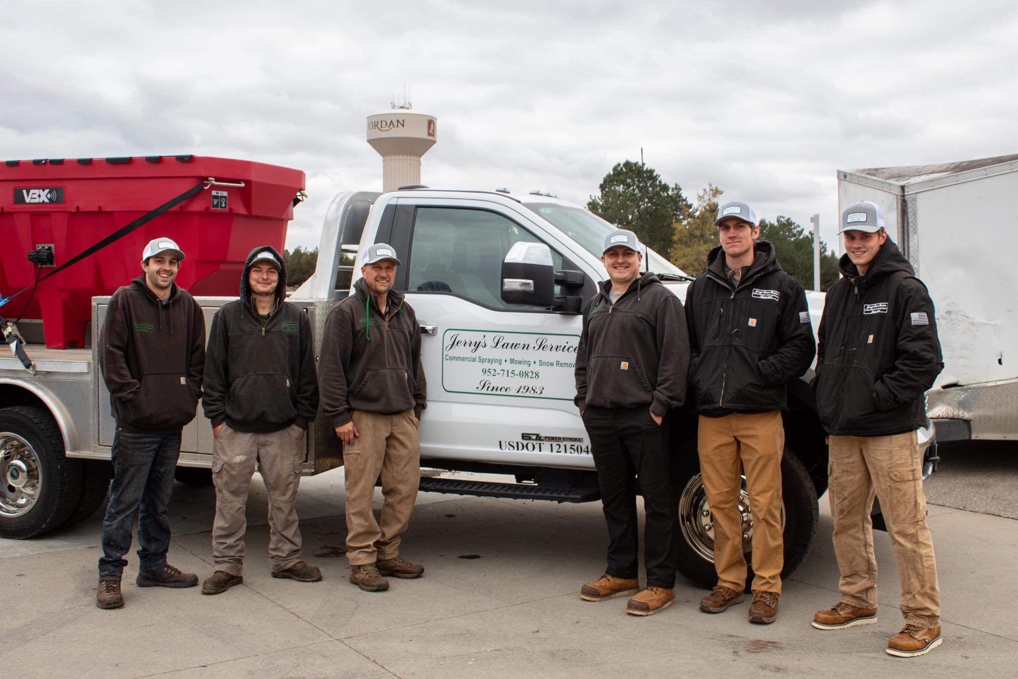 Various trucks and snow plows arranged in a semicircle at a service yard.